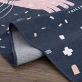 Close-up of the Milne Navy Dinosaur Washable Kids Rug showing the dinosaur pattern, navy color, and woven texture. Fold