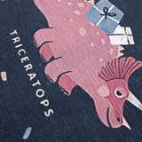 Close up of Milne Navy Dinosaur Washable Kids Rug featuring a pink triceratops with gifts on a navy blue background. Texture