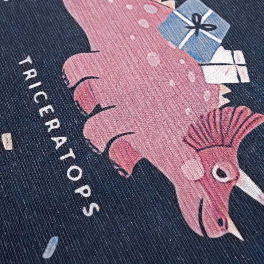 Close up of Milne Navy Dinosaur Washable Kids Rug featuring a pink triceratops with gifts on a navy blue background. Texture