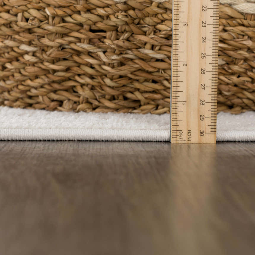 Close-up of the pile height of the Tabuan 3D Outdoor Area Rug. White thatch rug with a brown basket weave design. Pile