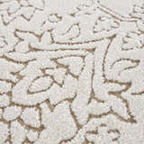 Close-up of the Tabuan 3D Outdoor Area Rug. White floral pattern with nutmeg accents and a textured, high-pile design. Texture