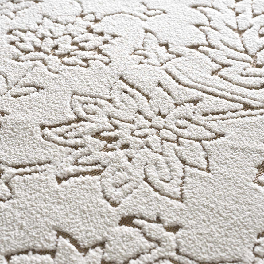 Close up of the Tabuan 3D Outdoor Area Rug showing a floral pattern in white thatch on a nutmeg background. Textured polypropylene. Texture