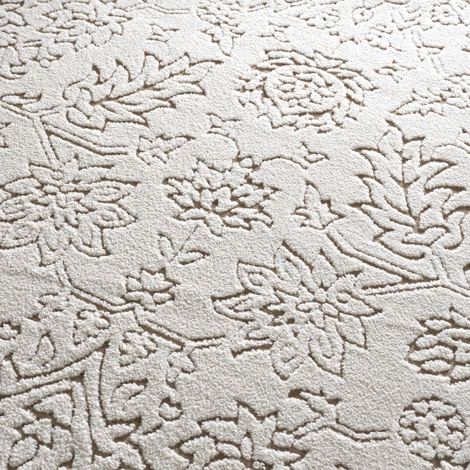 Close-up of the Tabuan 3D Outdoor Area Rug. Floral pattern in white thatch and nutmeg on a gray base. Coastal style. Texture