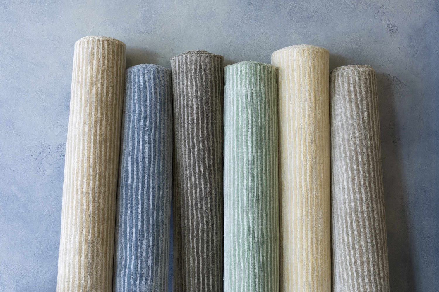 Rolled Ahmeek Area Rugs in gray, blue, green, and beige. Viscose rugs with subtle stripe pattern. Styleshot