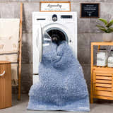 Aqua Faina shag rug being washed in a laundry room with a washing machine and laundry decor. Washing-Machine