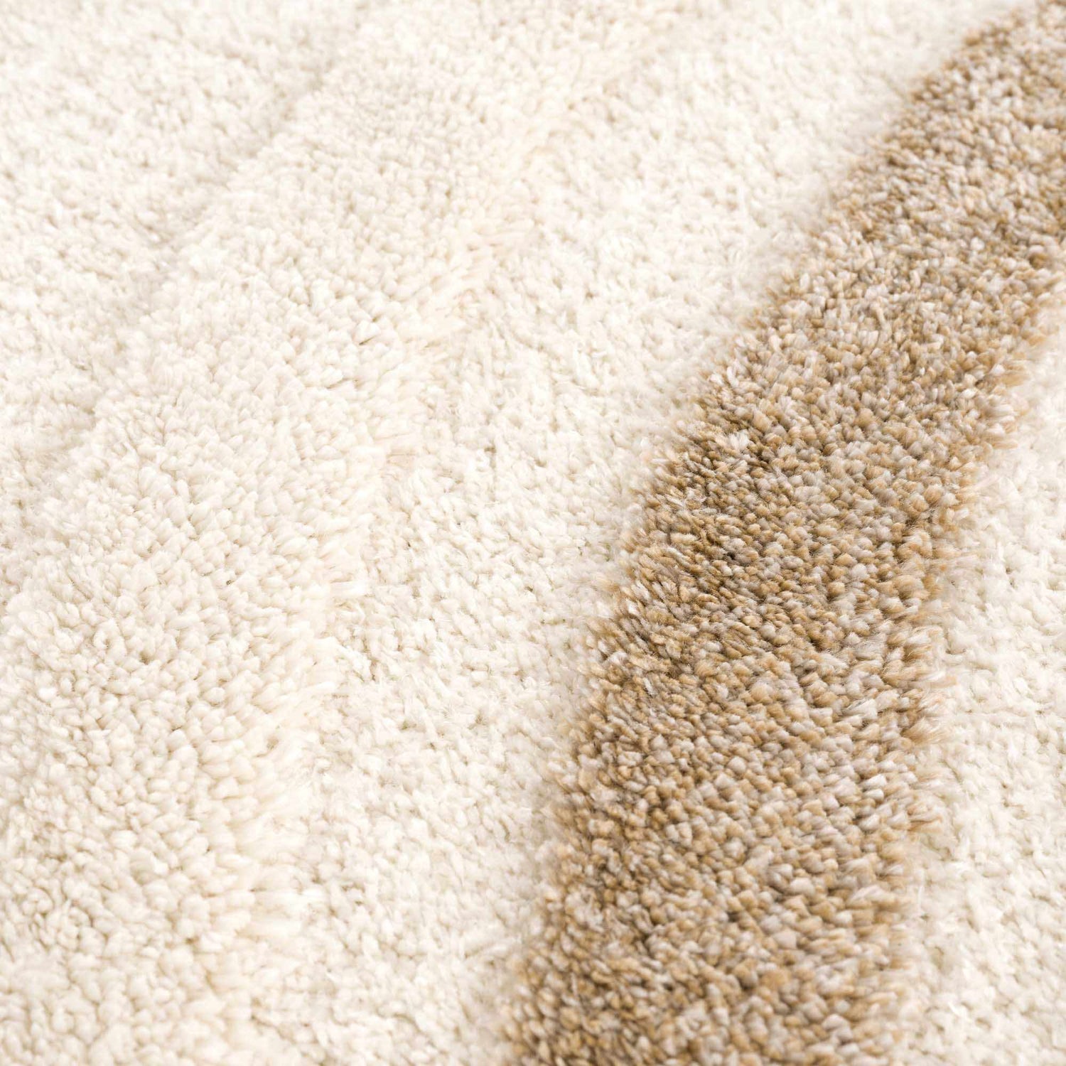 Close-up of the Espiye Area Rug showing its shag texture and striped pattern in driftwood and light peach colors. Texture