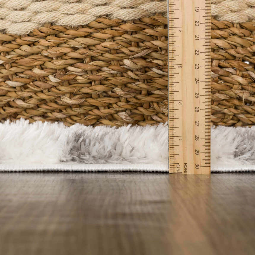 Close-up of the shag Lotta Area Rug showing gray and white fibers next to a basket and a ruler. Pile