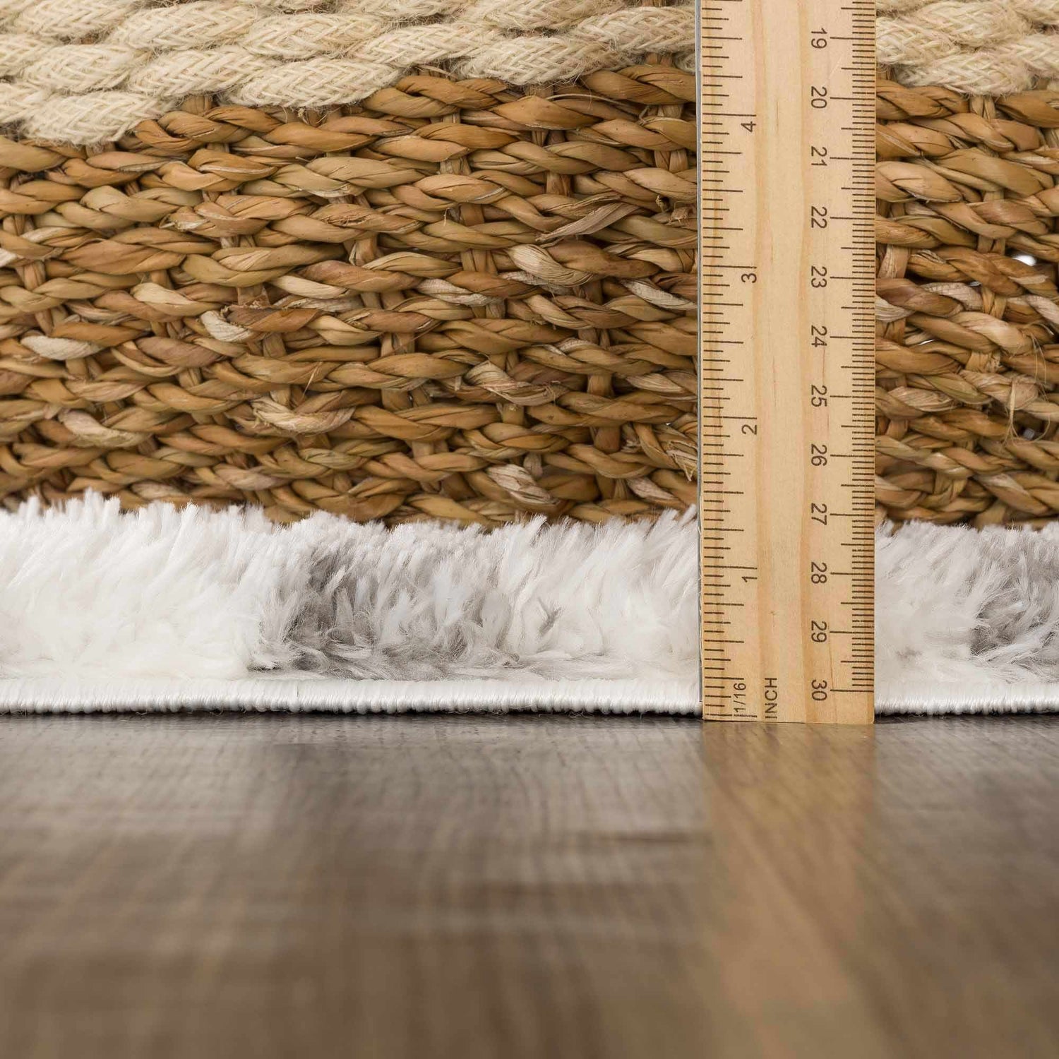 Close-up of the shag Lotta Area Rug showing gray and white fibers next to a basket and a ruler. Pile