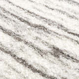 Close-up of the Lotta Area Rug. White shag rug with a subtle gray striped pattern. Soft, plush texture. Texture