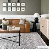 Living room scene with a gray Hedda Boutique Washable Rug, brown leather sofa, and black coffee table. Roomscene-Rectangle