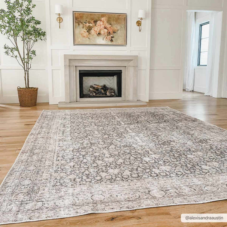 Living room with fireplace and light wood floors featuring the Hedda Boutique Washable Rug in gray. Roomscene-Rectangle