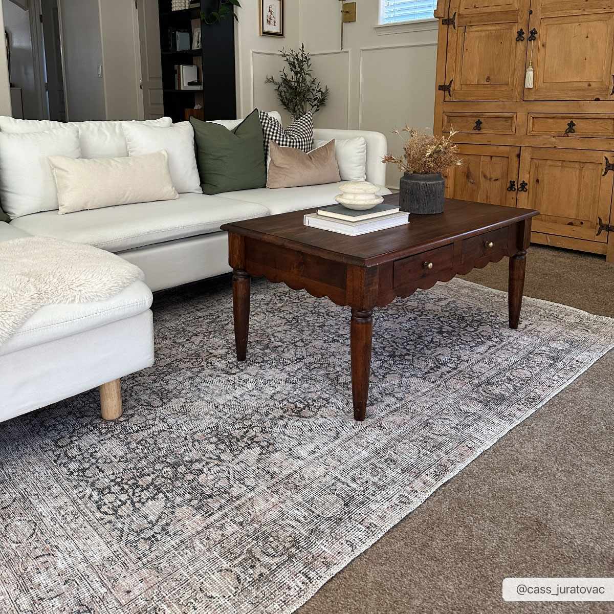 Living room scene with a white couch and Hedda Boutique Washable Rug in dark gray, brown coffee table, and a rustic wood cabinet. Roomscene-Rectangle