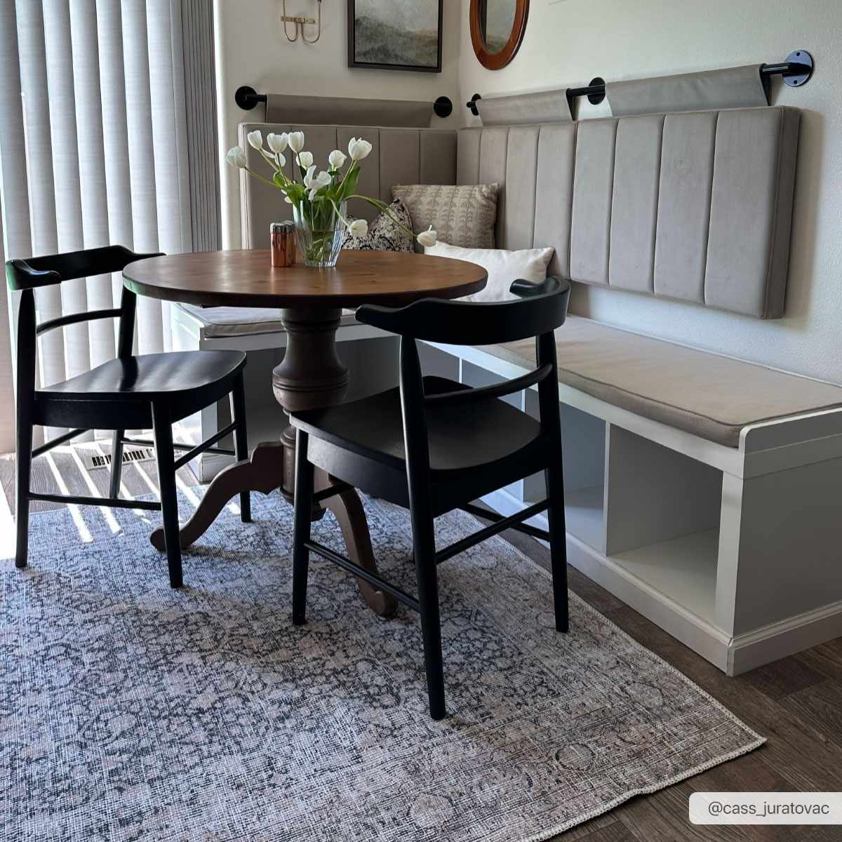 Dining room with gray Hedda Boutique Washable Rug, round wood table, black chairs, and built-in bench seating. Roomscene-Rectangle
