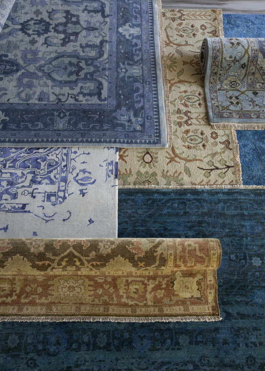 Close-up of various Brentford Carpet rugs in black, brown, oatmeal, olive, and tan colors with traditional patterns. Styleshot