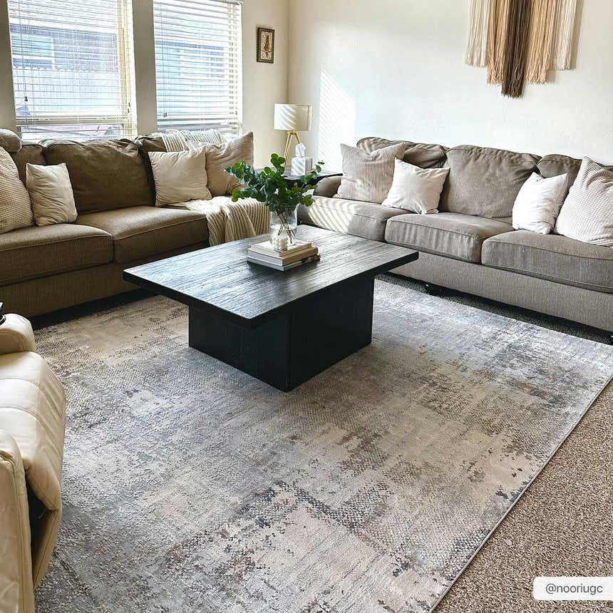 Living room with neutral sofas and a black coffee table on the Ironwood Textured Luxe Rug in charcoal, gray, and taupe. Roomscene-Rectangle