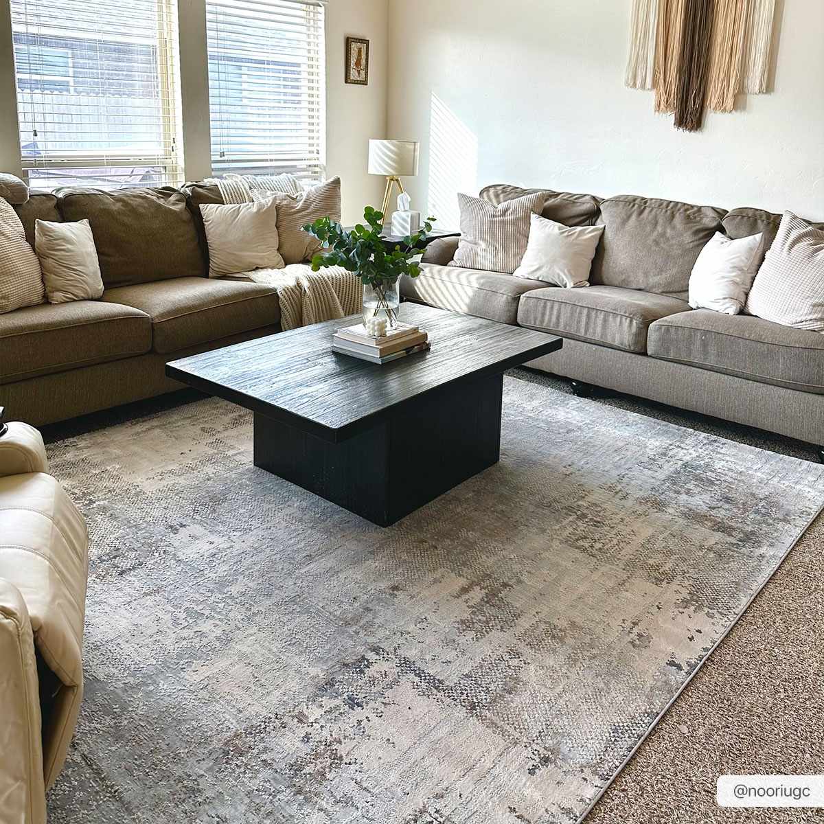 Living room with neutral sofas and a black coffee table on the Ironwood Textured Luxe Rug in charcoal, gray, and taupe. Roomscene-Rectangle
