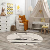 Nursery with crib, dresser, and round Kids Dinosaur Animal Print Area Rug in bone, dark gray, and nutmeg. Roomscene-Round
