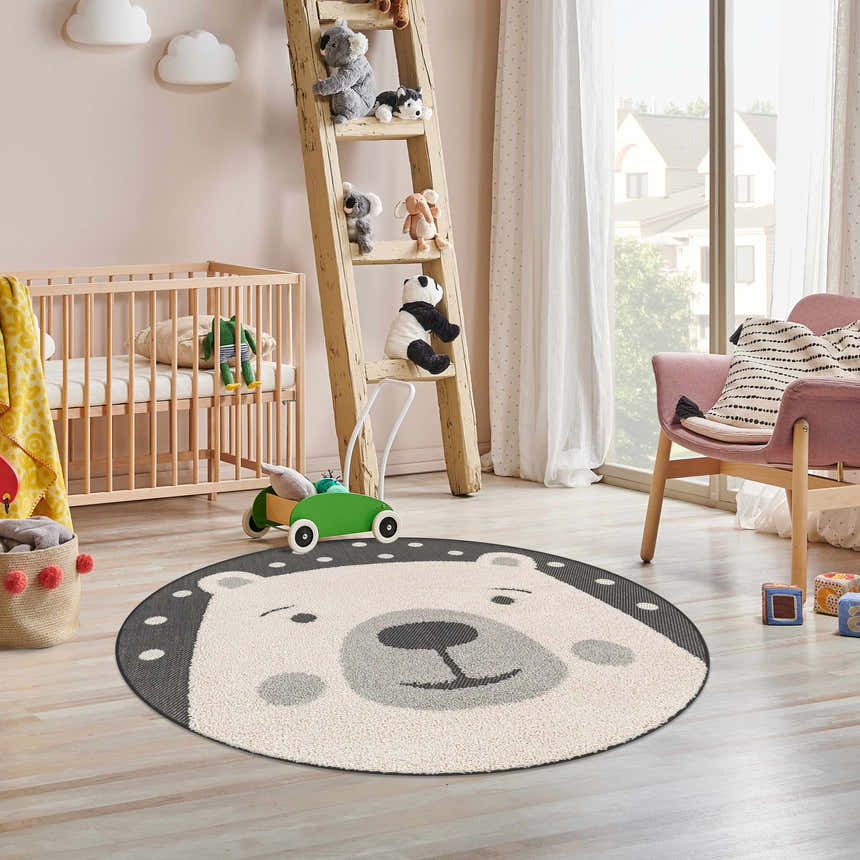 Kids nursery with crib, ladder with stuffed animals, and round Kids Bear Animal Print Area Rug. Roomscene-Round