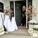 Festive front porch with ghosts, pumpkins, and Kidron Area Rug in beige and black. Halloween decor. Roomscene-Rectangle