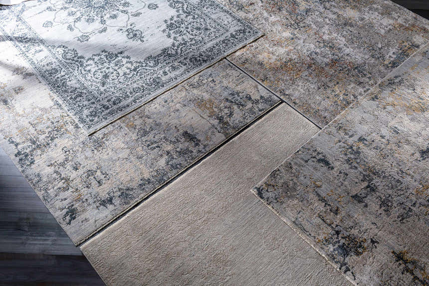 Close-up of Midfield Luxe Rug samples in charcoal, cream, and gray. Contemporary rug designs and textures. Styleshot