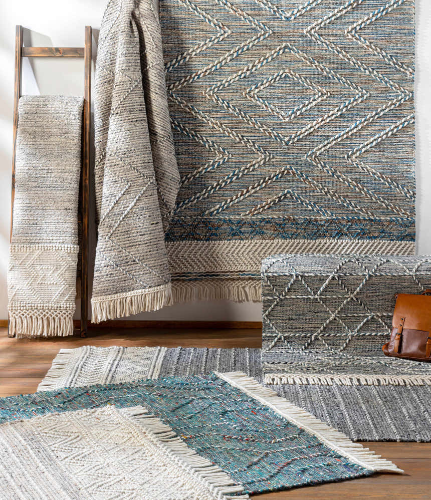 Close-up of Charcoal Cream Arguvan rug with braided diamond pattern, tassels, and wool blend texture. Contemporary, farmhouse style. Styleshot