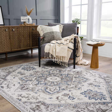 Living room scene with a Bakir Area Rug in blue and gray, wood floors, and a gray accent chair. Roomscene-Rectangle