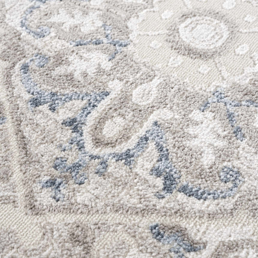Close-up of the Bakir Area Rug showing its blue and gray traditional pattern and soft, textured weave. Texture