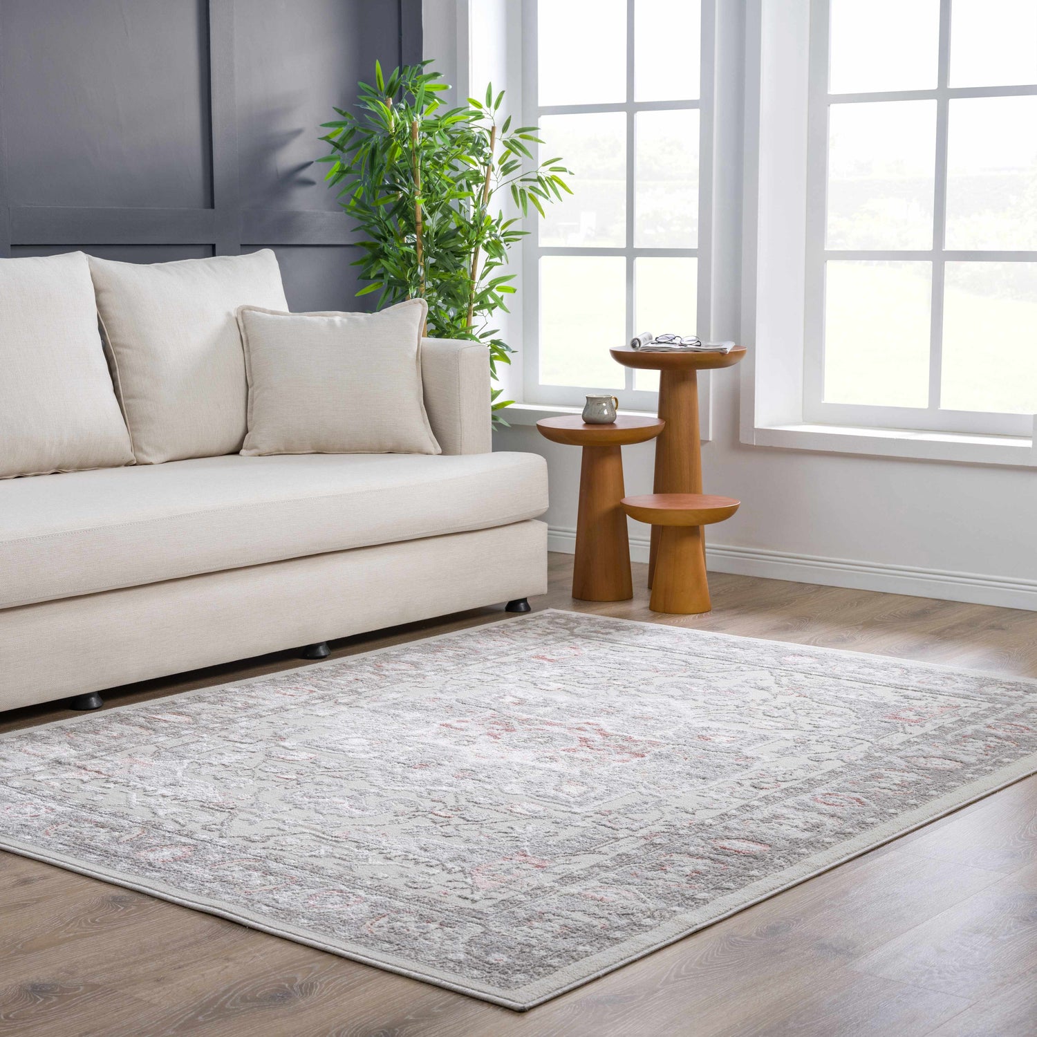 Bright living room scene with a gray and pink Damla Area Rug, cream sofa, and wood accent tables. Roomscene-Rectangle