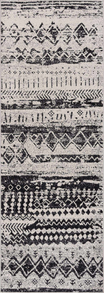 Close-up of the Lyssons Washable Area Rug. Black, gray, and light gray geometric pattern. Contemporary, farmhouse style. Design-Runner