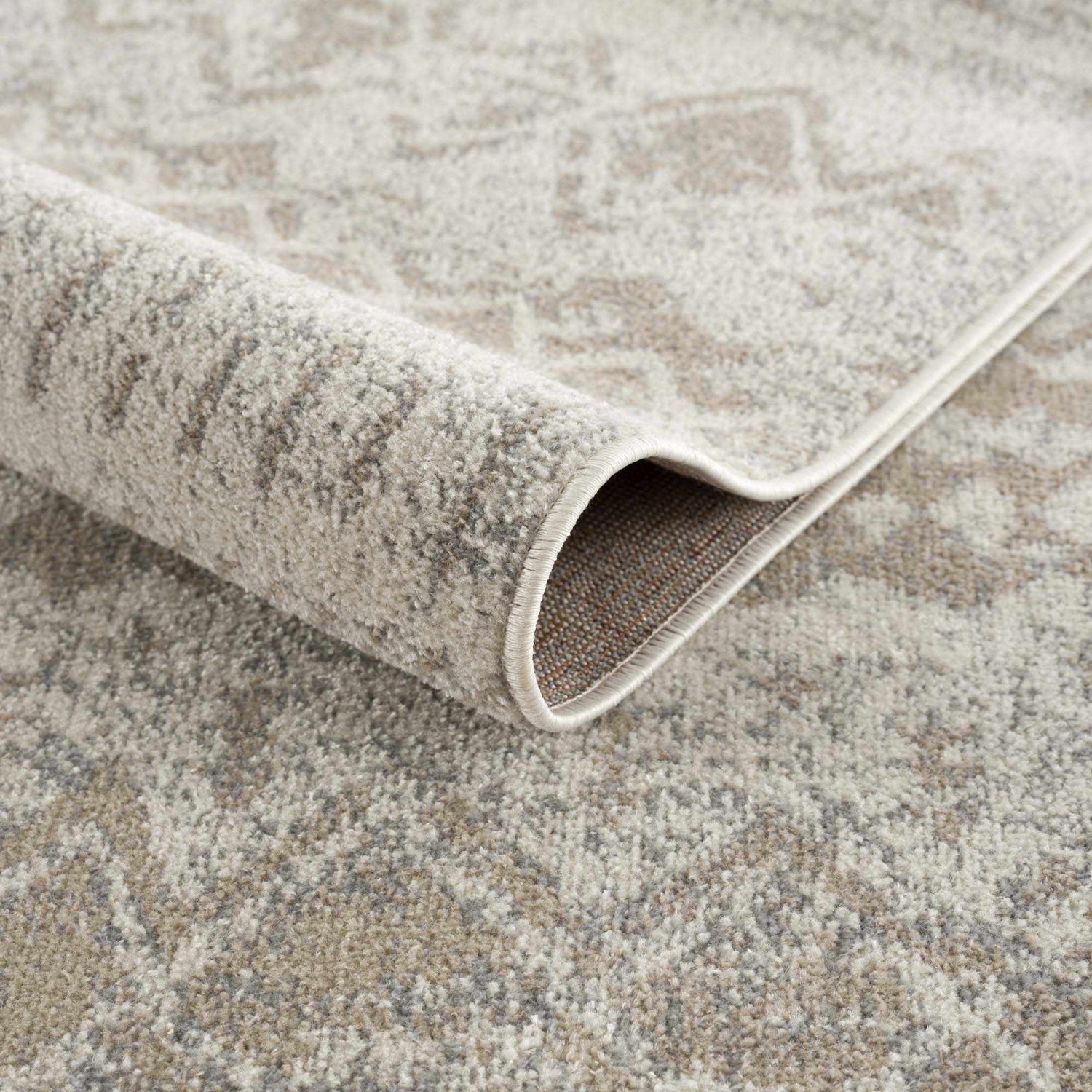 Close-up of Tupsan Washable Area Rug showing its cream, beige, and gray contemporary pattern and machine-woven construction. Fold