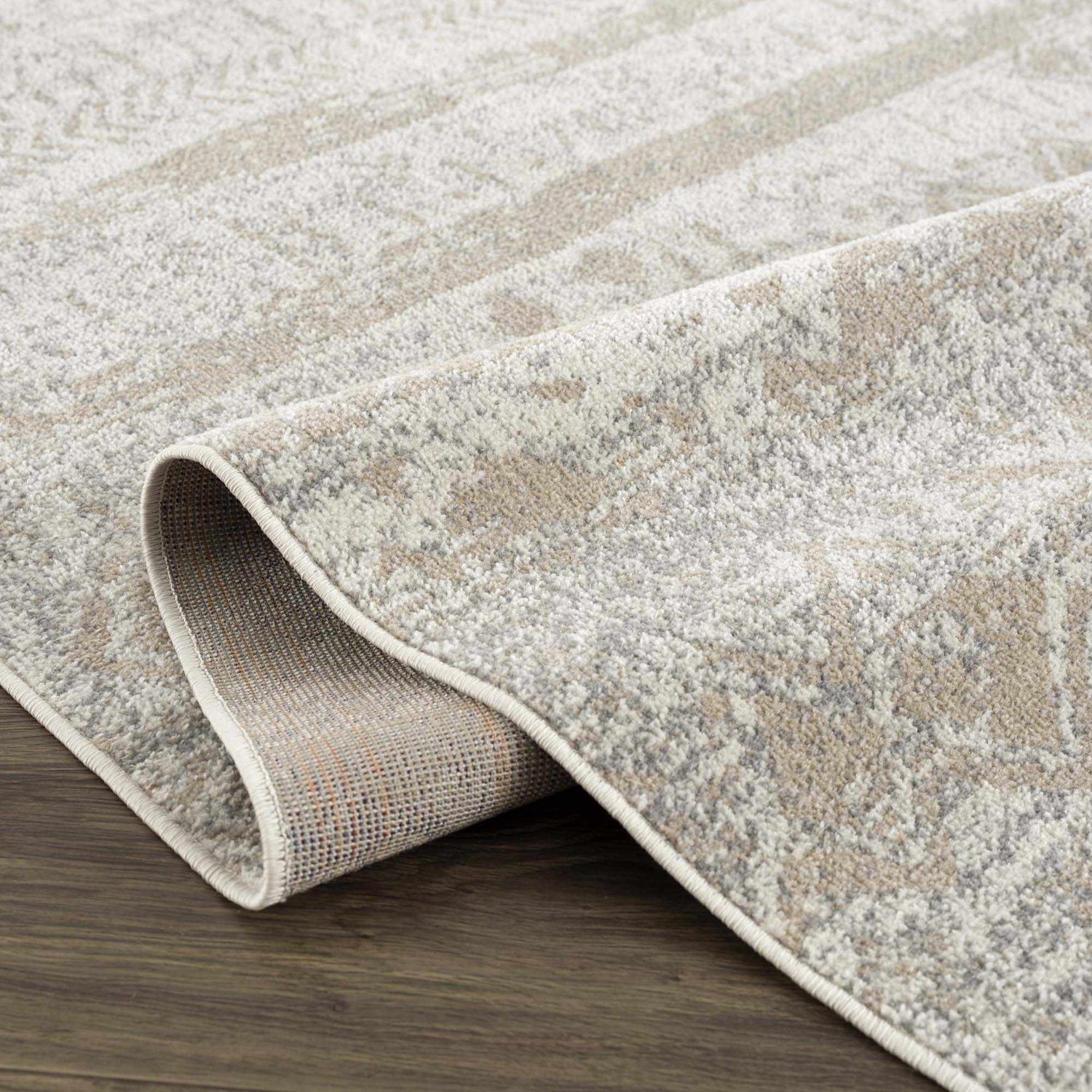Close-up of the Tupsan Washable Area Rug showing its cream, light beige, and light gray contemporary pattern and soft texture. Fold