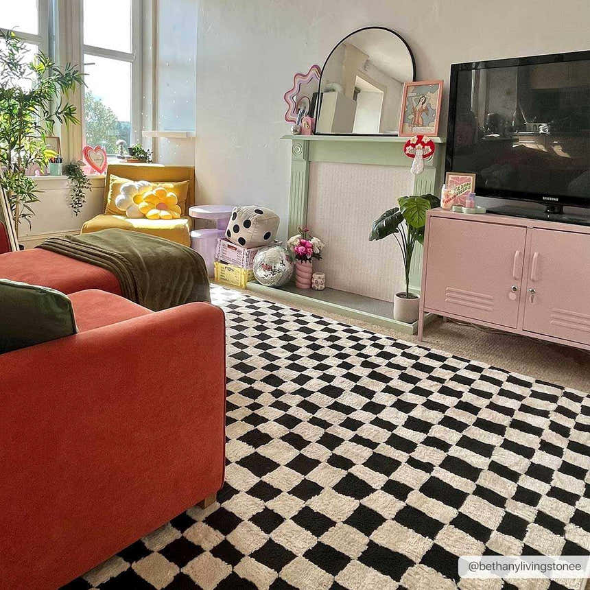 Eclectic living room with orange sofa and Lajos Black & White Checkered Plush Rug. Playful, modern style. Roomscene-Rectangle