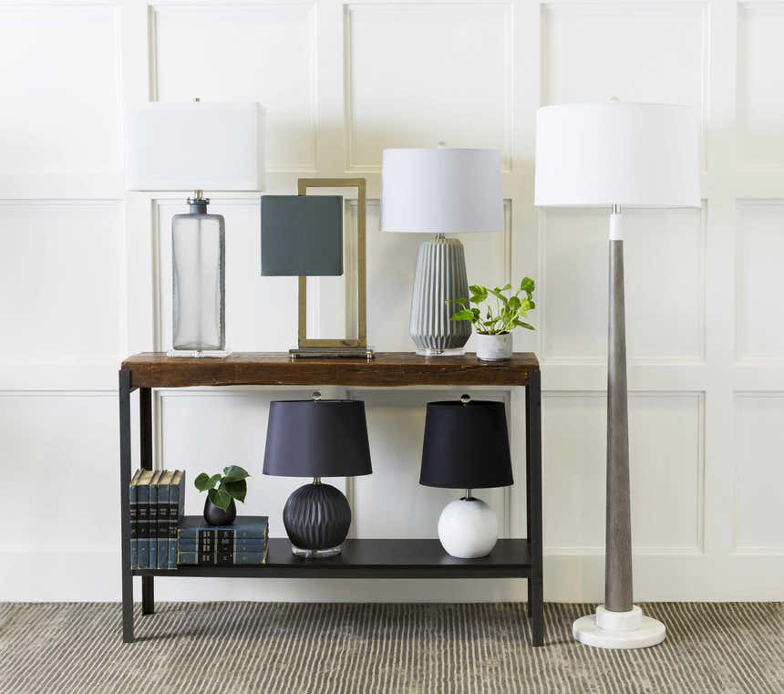 Console table styled on Angie Area Rug in charcoal with striped pattern. Lamps, books, and plants decorate the scene. Styleshot