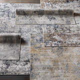 Close-up of the Hayle Area Rug showcasing its charcoal, gray, mustard, and off-white contemporary abstract design. Styleshot