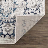 Close-up of the Duena Area Rug showing the traditional blue and light gray pattern and rug backing. Fold