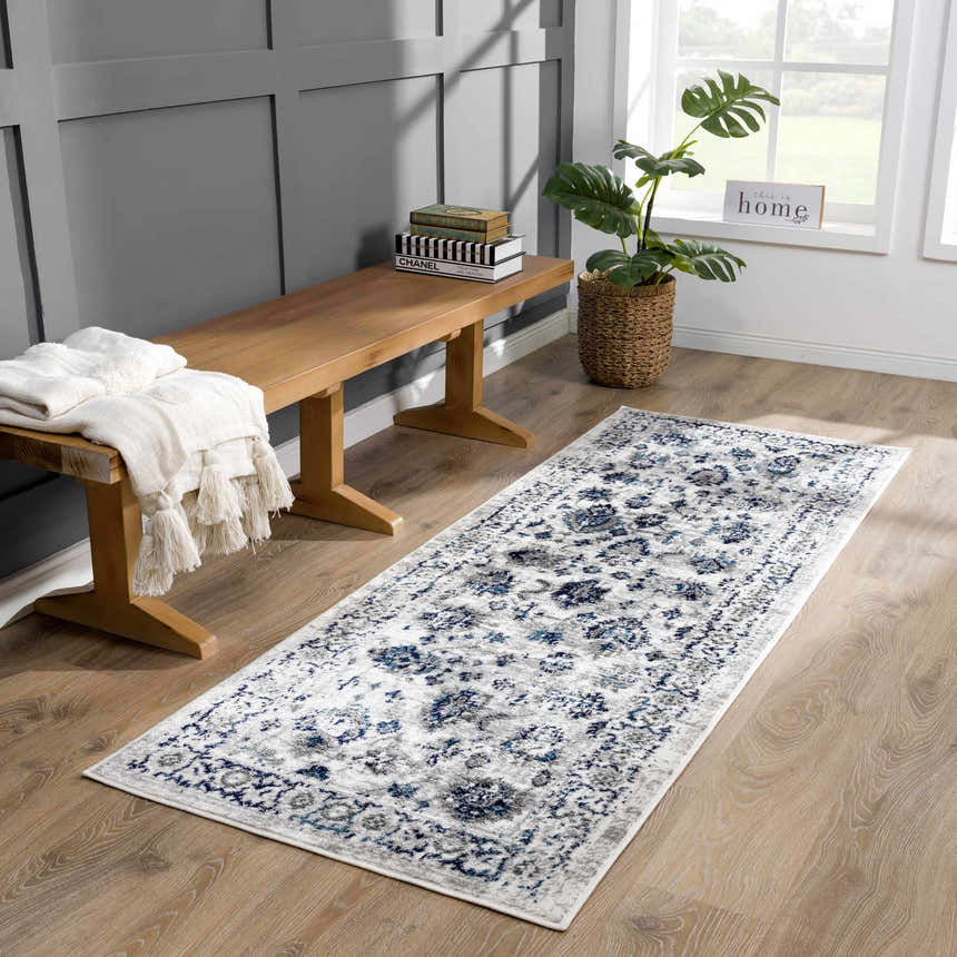 Entryway with Duena Area Rug runner in blue and light gray, wood bench, and potted plant. Roomscene-Runner