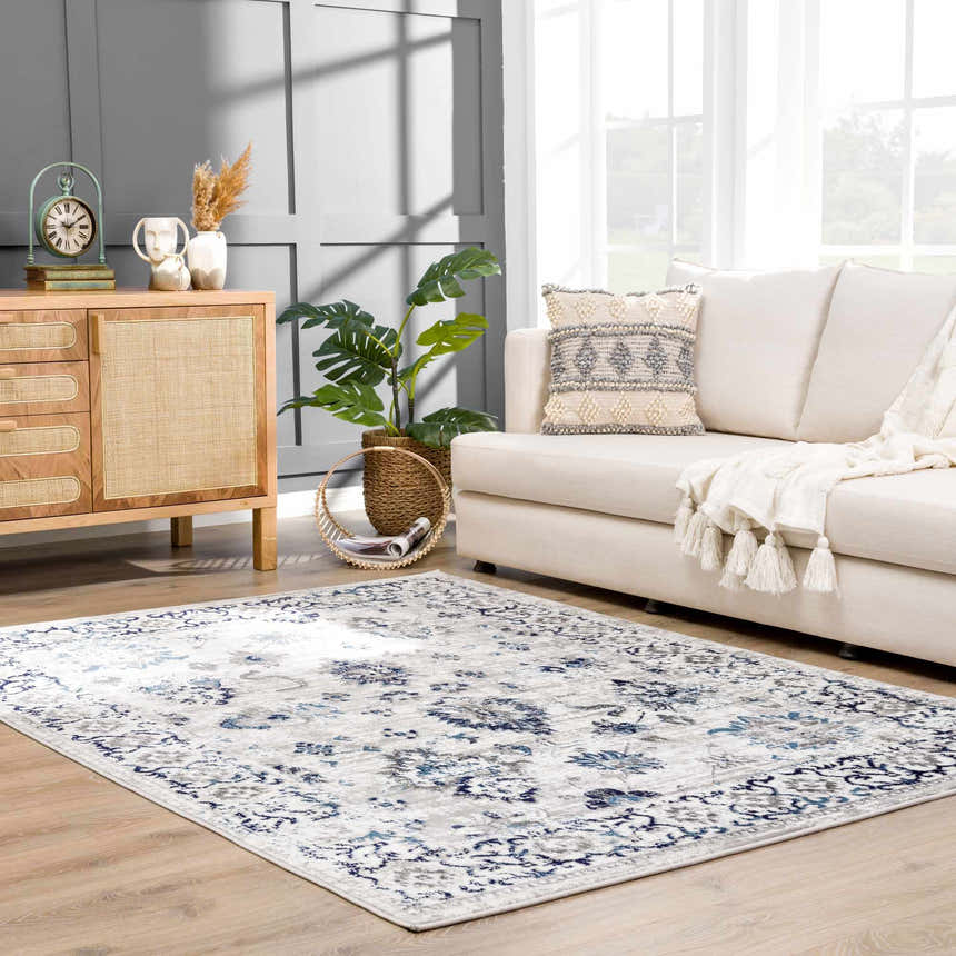 Living room scene with a blue and light gray Duena Area Rug, white sofa, and wood cabinet. Roomscene-Rectangle