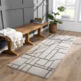 Entryway scene with gray walls, wood bench, and silver geometric Andia Gray Area Rug. Roomscene-Runner