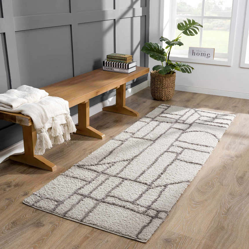 Entryway scene with gray walls, wood bench, and silver geometric Andia Gray Area Rug. Roomscene-Runner