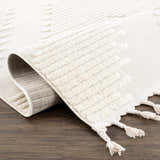 Close-up of the Palimbang Cream 3D Rug showing its geometric pattern, tassels, and textured, machine-woven construction. Fold