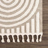 Close-up of the Moise Area Rug, featuring a beige and cream geometric pattern and decorative tassels. Swatch