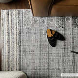 Close-up of the Naivasha Elegant High/Low Area Rug in charcoal and cream, with a textured, geometric design. Styleshot
