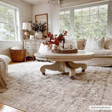 Farmhouse living room with beige Njeri Area Rug, white sofa, and round coffee table. Neutral, cozy aesthetic. Roomscene-Rectangle