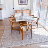 Dining room with Nyla Bone rug under a marble table and wooden chairs, bathed in natural light. Roomscene-Rectangle