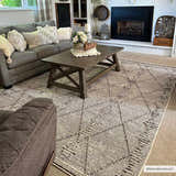 Cozy living room with gray sofa and Nyla Bone Indoor Outdoor Rug. The rug features a geometric diamond pattern. Roomscene-Rectangle