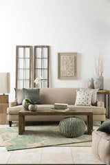 Living room scene with Briceville Premium Area Rug in ivory, green, blue, peach, and wheat colors. Contemporary, mid-century modern style. Styleshot