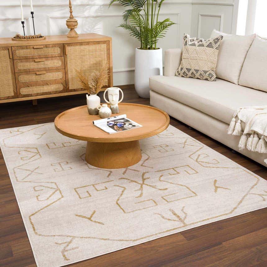 Living room scene with a cream sofa and the Azzan Cream & Gold Area Rug, featuring a geometric design. Roomscene-Rectangle