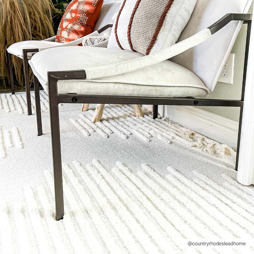 Living room scene with modern chairs on a Palimbang Cream 3D Rug. The rug has a geometric pattern and soft texture. Roomscene-Rectangle