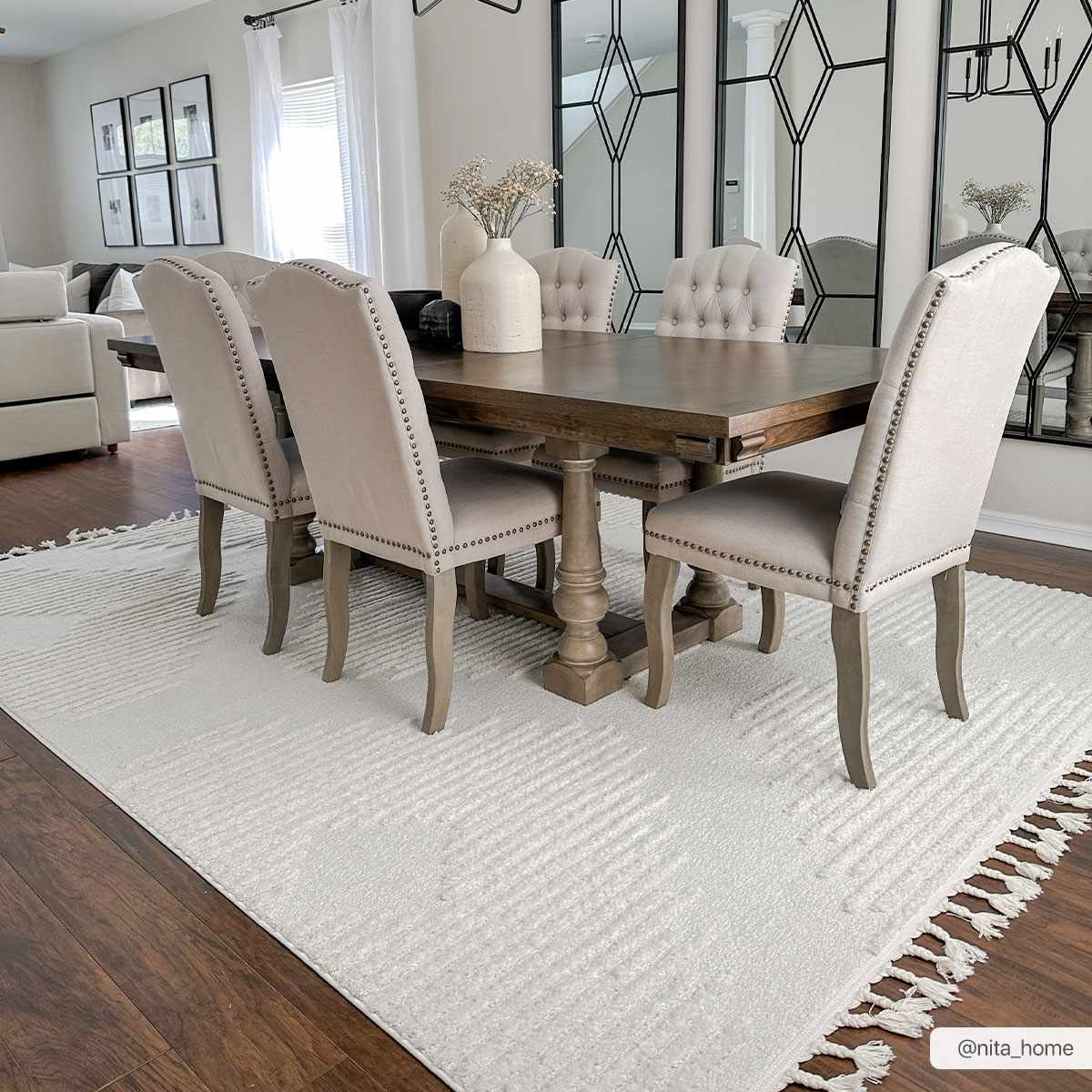 Dining room with wood table, upholstered chairs, and Palimbang Cream 3D Rug with geometric design and tassels. Roomscene-Rectangle