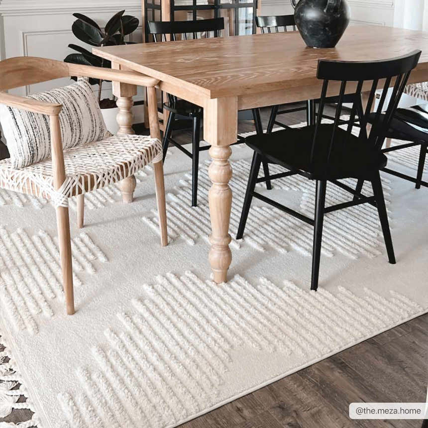Dining room scene with a light wood table and black chairs on the Palimbang Cream 3D Rug. Roomscene-Rectangle